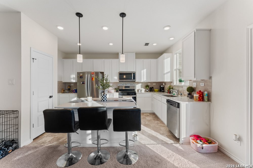 9422 Braman Converse, TX 78109 - Photo 13 of 26 a kitchen with kitchen island stainless steel appliances a dining table chairs sink and cabinets