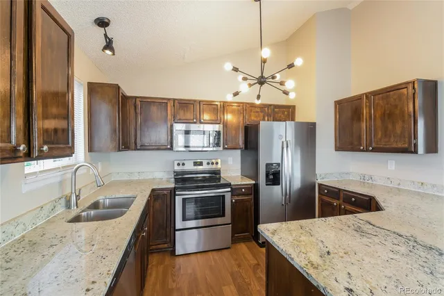 a kitchen with stainless steel appliances granite countertop a sink stove and refrigerator