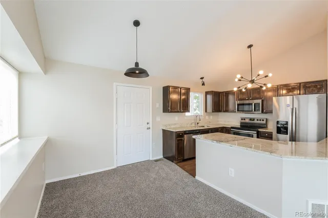 a kitchen with stainless steel appliances granite countertop a sink a stove and refrigerator