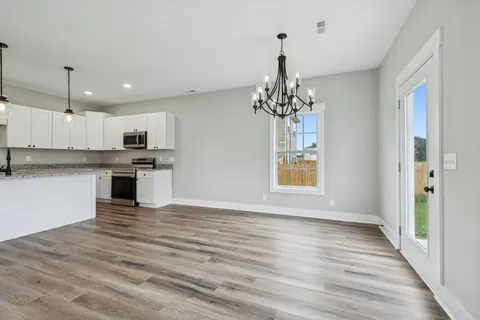 a view of kitchen with granite countertop cabinets and wooden floor