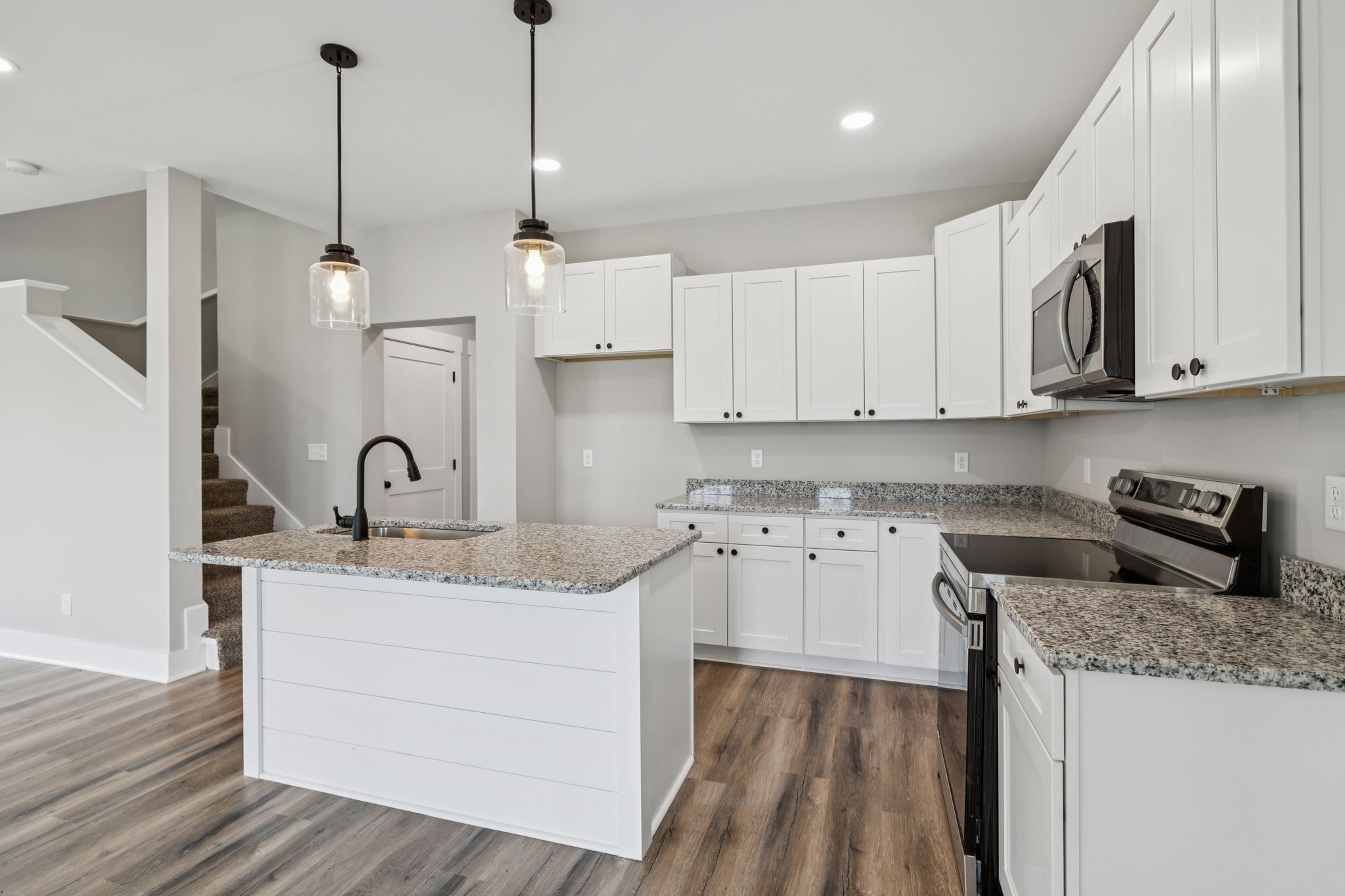 700 Robinson Road Smithville, TN 37166 - Photo 13 of 36 a kitchen with stainless steel appliances granite countertop a sink a stove and a wooden floor