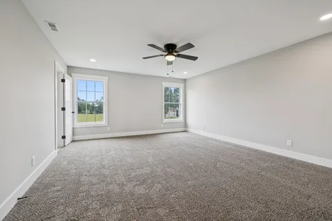 a view of a room with a ceiling fan and a window