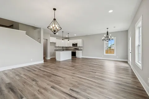 a view of a kitchen with wooden floor and a ceiling fan