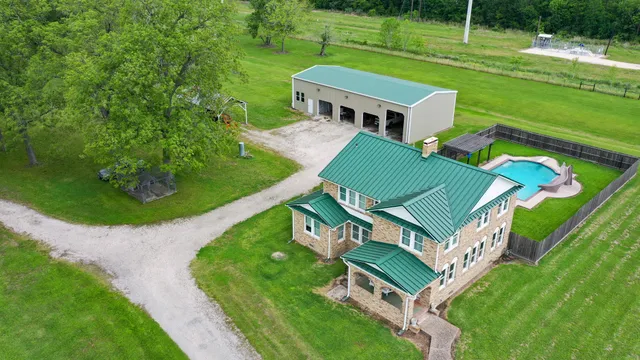 an aerial view of a house with a big yard