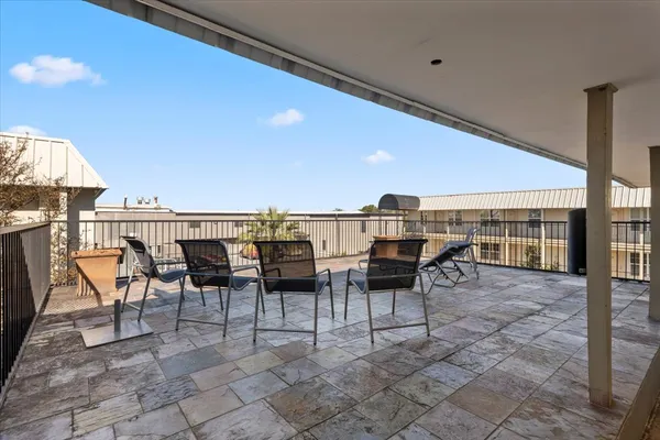 a view of a terrace with furniture and floor to ceiling window