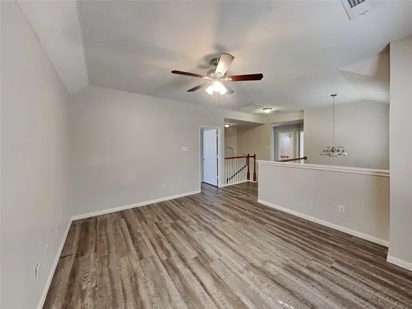 a view of kitchen and empty room with wooden floor