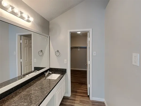 a bathroom with a granite countertop sink and a mirror