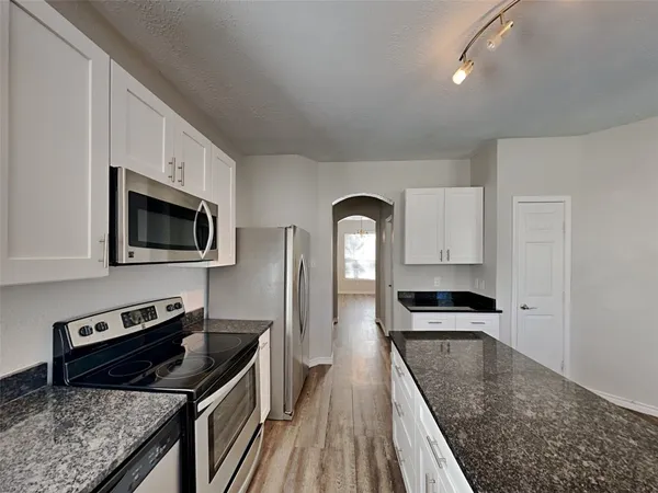 a kitchen with stainless steel appliances granite countertop a stove a sink and a refrigerator