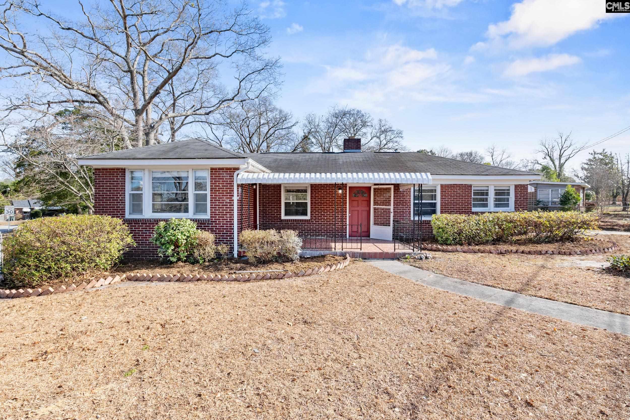 409 Wilkes Road Columbia, SC 29203 - Photo 1 of 34 a front view of a house with a garden