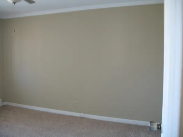an empty room with wooden floor and chandelier fan