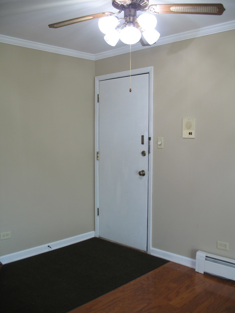 709 65th Street, Unit 5 Westmont, IL 60559 - Photo 15 of 15 an empty room with wooden floor and chandelier fan