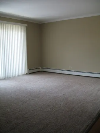 an empty room with wooden floor closet and windows