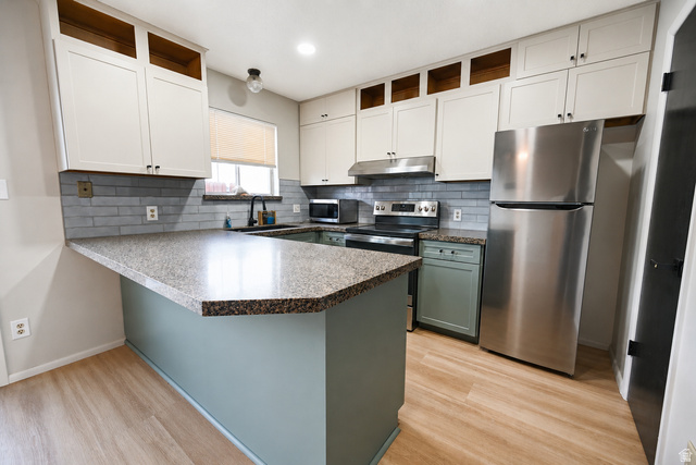 285 West 600 North, Unit 2 Logan, UT 84321 - Photo 8 of 21 Kitchen featuring light-finish cabinetry, speckled countertops, and a subway tile backsplash