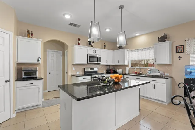 a living room with furniture a fireplace and a chandelier