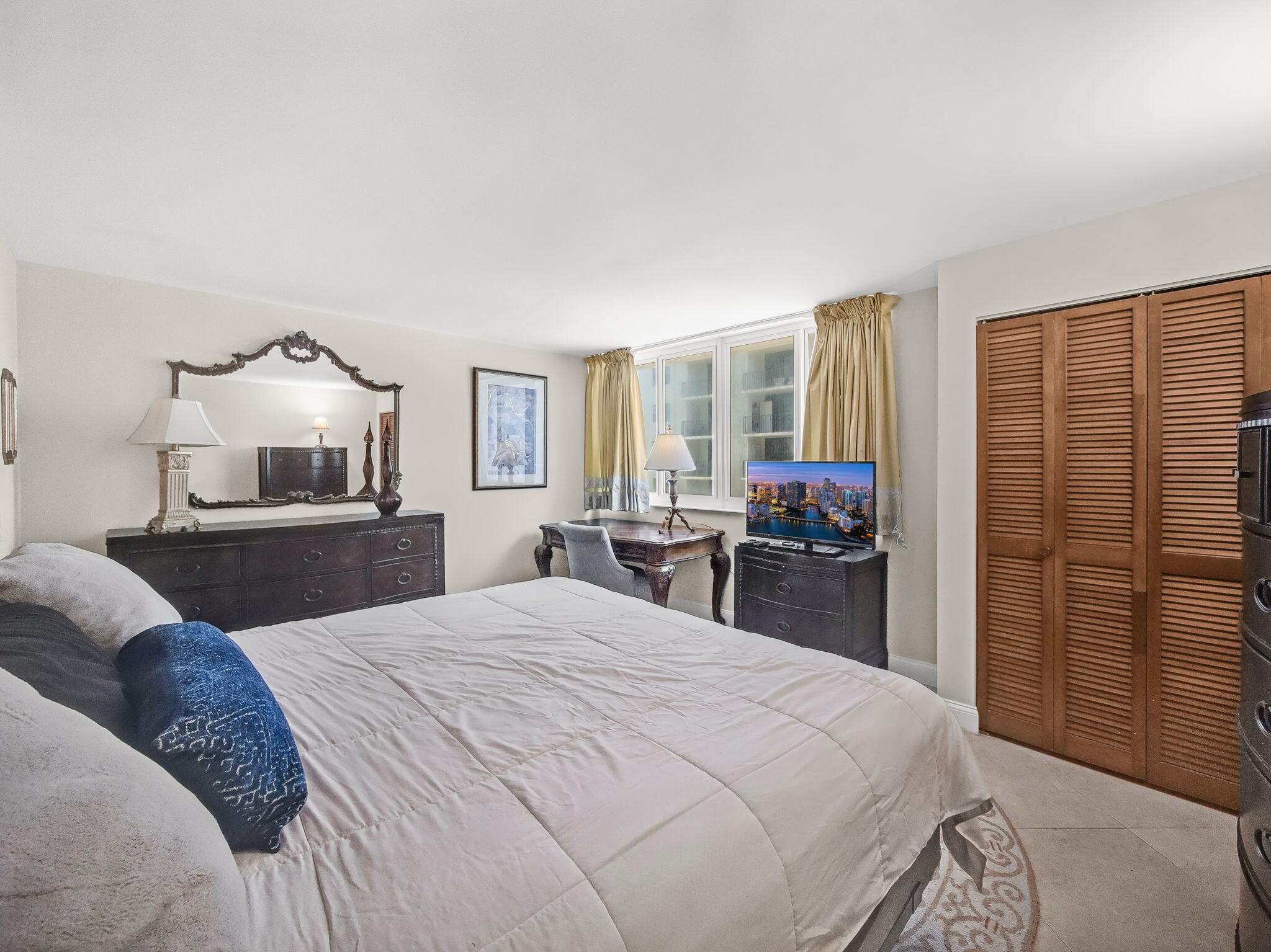 125 South Ocean Avenue, Unit 303 Palm Beach Shores, FL 33404 - Photo 12 of 20 a bedroom with a large bed and a flat tv screen