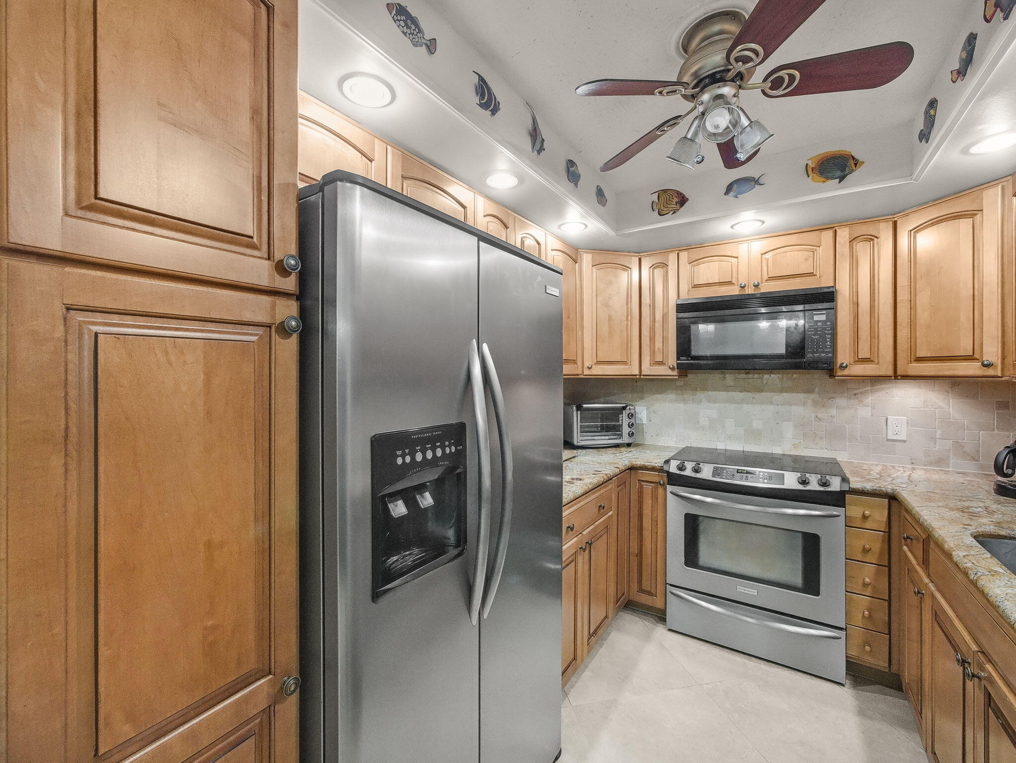 125 South Ocean Avenue, Unit 303 Palm Beach Shores, FL 33404 - Photo 8 of 20 a kitchen with stainless steel appliances granite countertop a refrigerator a stove and a sink with cabinets