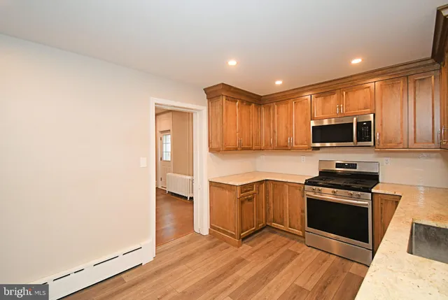 a kitchen with granite countertop stainless steel appliances and wooden cabinets
