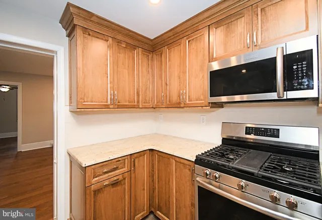 a kitchen with stainless steel appliances granite countertop a stove and a microwave