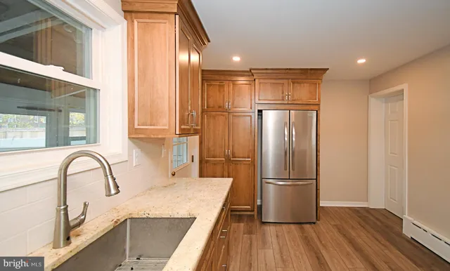 a kitchen with stainless steel appliances granite countertop a refrigerator and a sink
