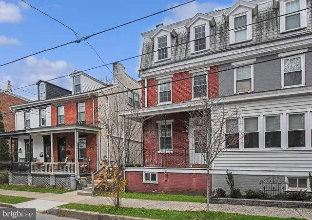 a front view of a residential apartment building with a yard