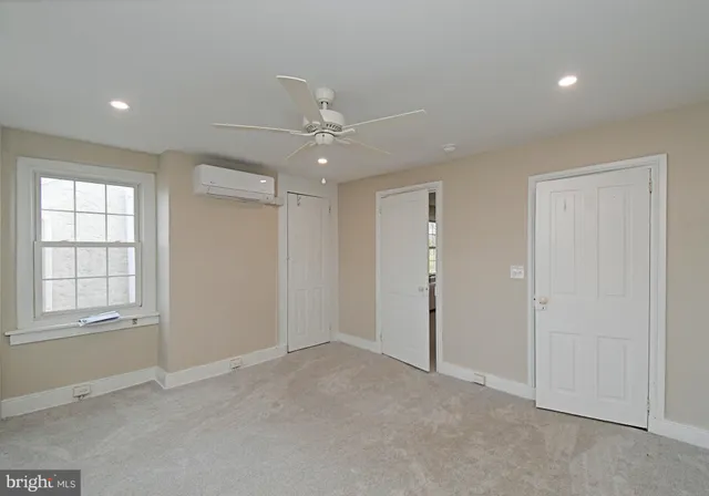 an empty room with windows and closet