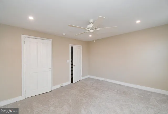an empty room with a ceiling fan and a window