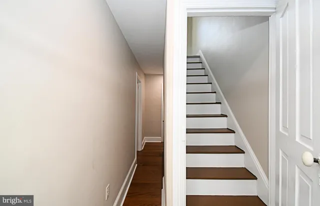 a view of a hallway with white walls and black white wall