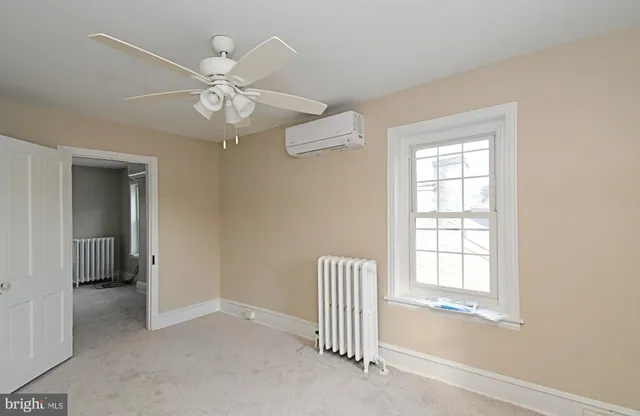 an empty room with a ceiling fan and a window