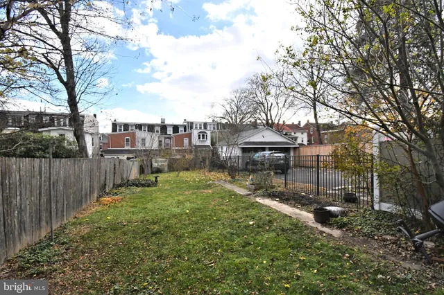 a view of a house with a backyard and a tree