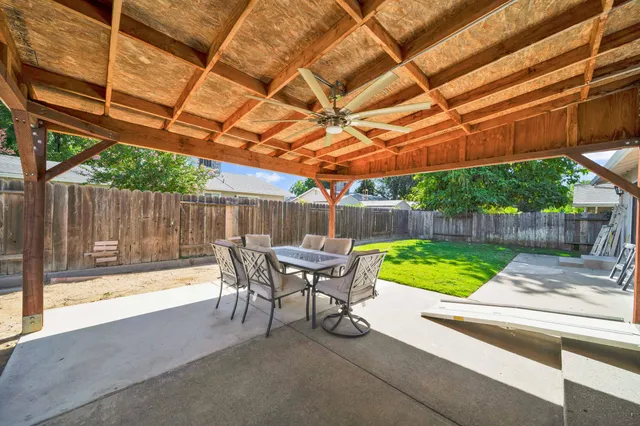 a view of a patio with a table and chairs under an umbrella