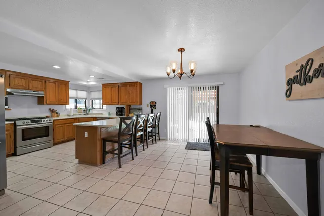 a kitchen with stainless steel appliances a table chairs and a refrigerator