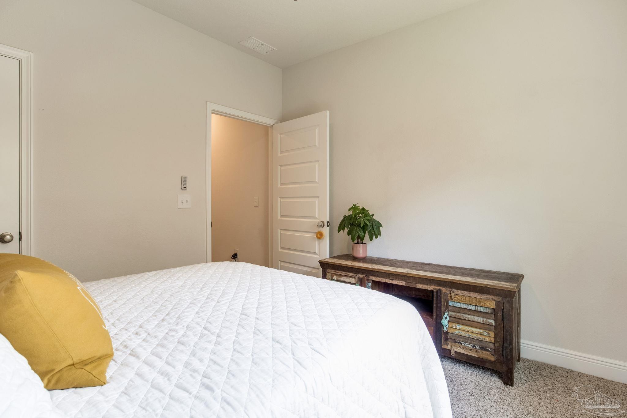 7990 Burnside Loop Pensacola, FL 32526 - Photo 33 of 61 a bedroom with a bed and a potted plant