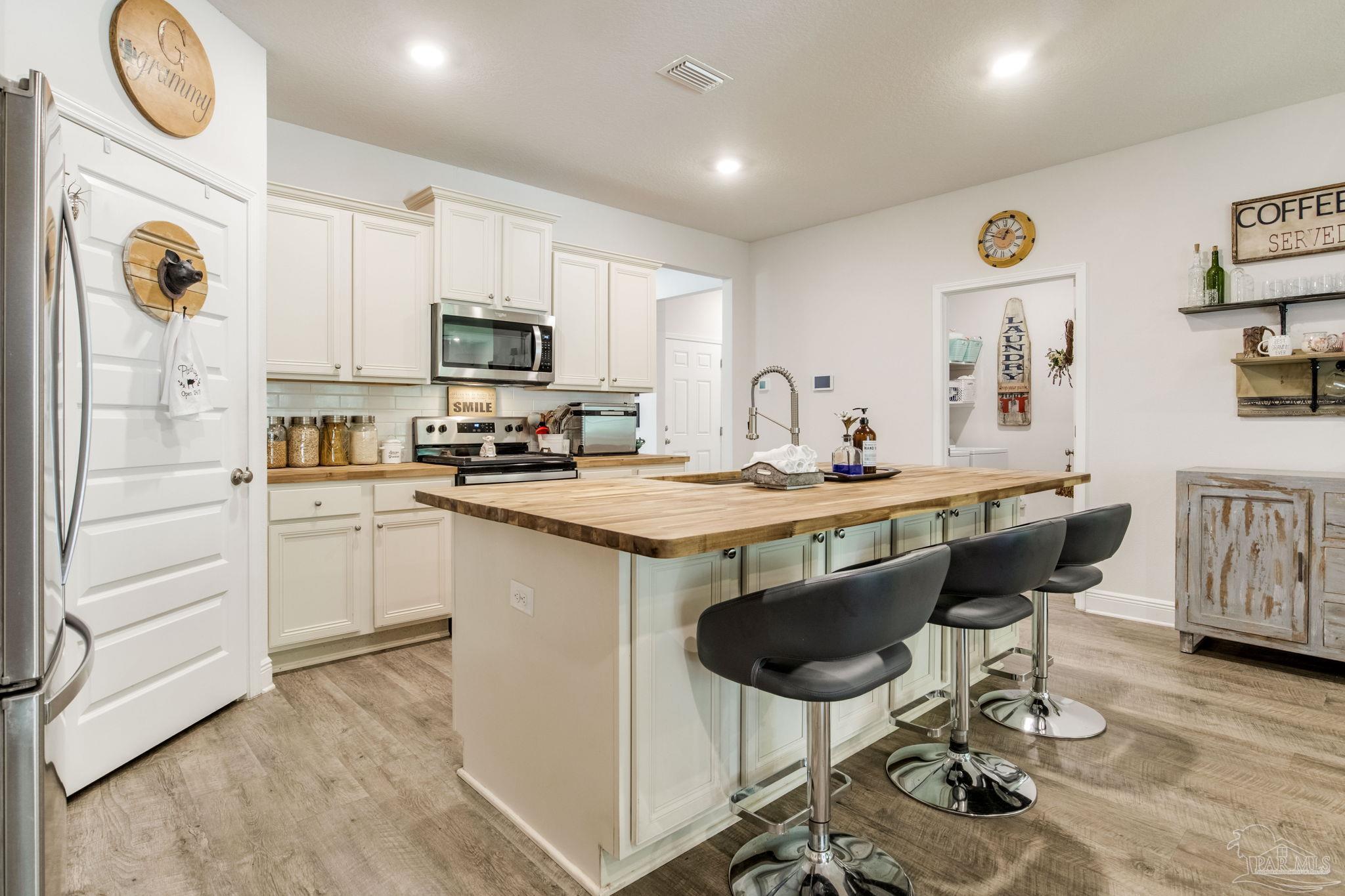 7990 Burnside Loop Pensacola, FL 32526 - Photo 8 of 61 a kitchen with a table chairs stove and cabinets