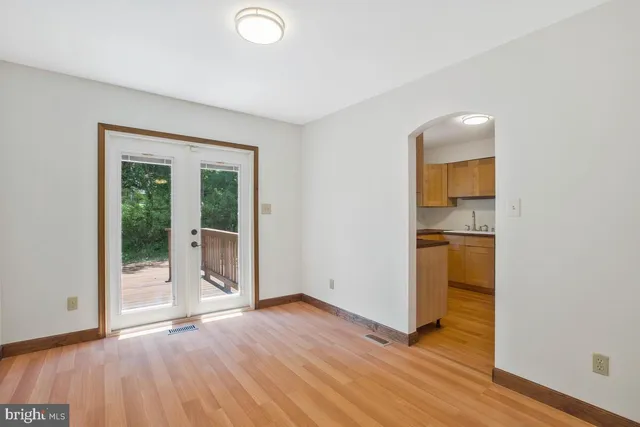 an empty room with wooden floor and entrance