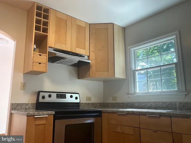 a kitchen with stainless steel appliances granite countertop a sink stove and cabinets