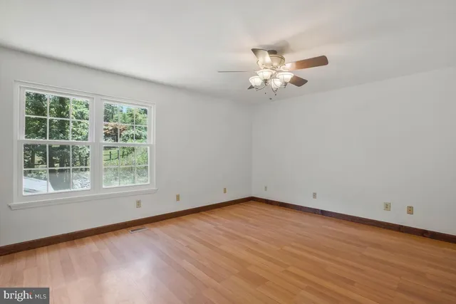 wooden floor in an empty room with a window