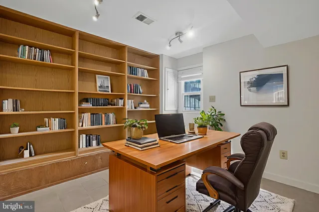 a view of a workspace with furniture and a bookshelf