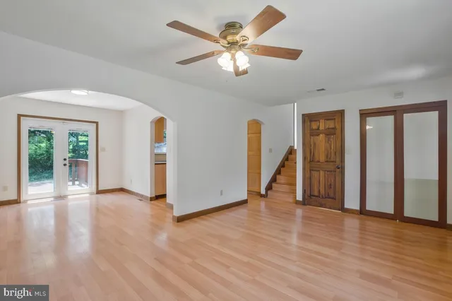 a view of an empty room with a window and wooden floor