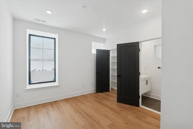 an empty room with closet and wooden floor