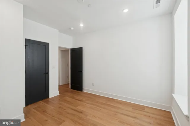 an empty room with wooden floor and closet