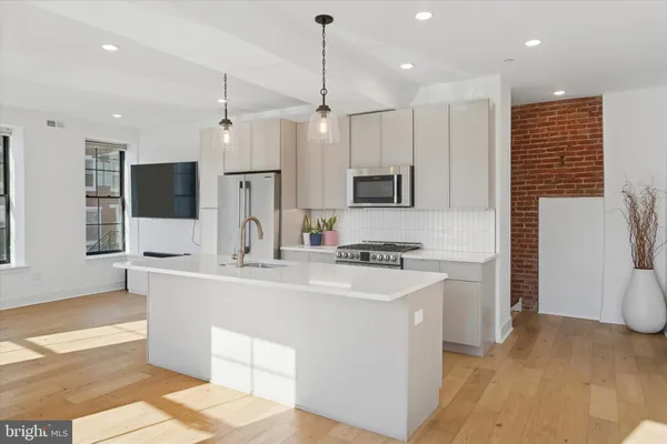 a large kitchen with kitchen island a sink stainless steel appliances and cabinets