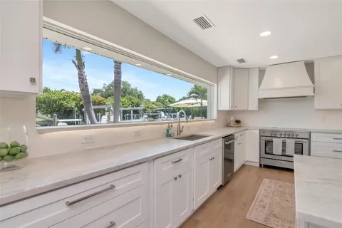 a view of a kitchen with a sink and washer dryer