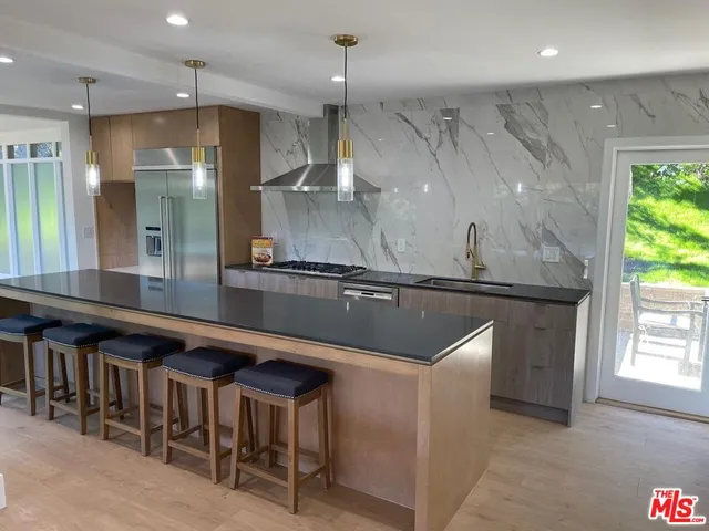 a kitchen with a sink a counter space and stainless steel appliances