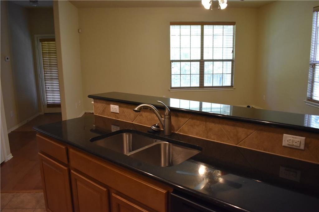 1310 West Parmer Lane, Unit 1503 Austin, TX 78727 - Photo 4 of 26 Kitchen with healthy amount of natural light, wood finish cabinetry, and dark stone counters