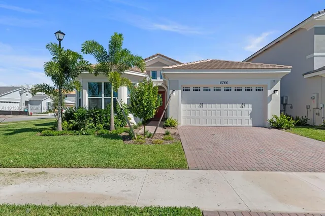 a front view of a house with a yard and a garage