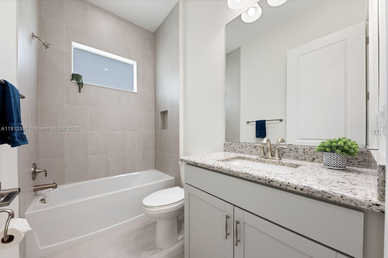 5786 Aleppo Pne Place Westlake, FL 33470 - Photo 20 of 30 a bathroom with a granite countertop sink toilet and bathtub