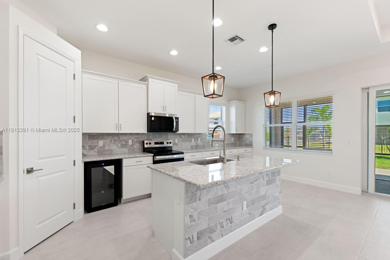 5786 Aleppo Pne Place Westlake, FL 33470 - Photo 8 of 30 a kitchen with stainless steel appliances granite countertop a sink a stove and a refrigerator