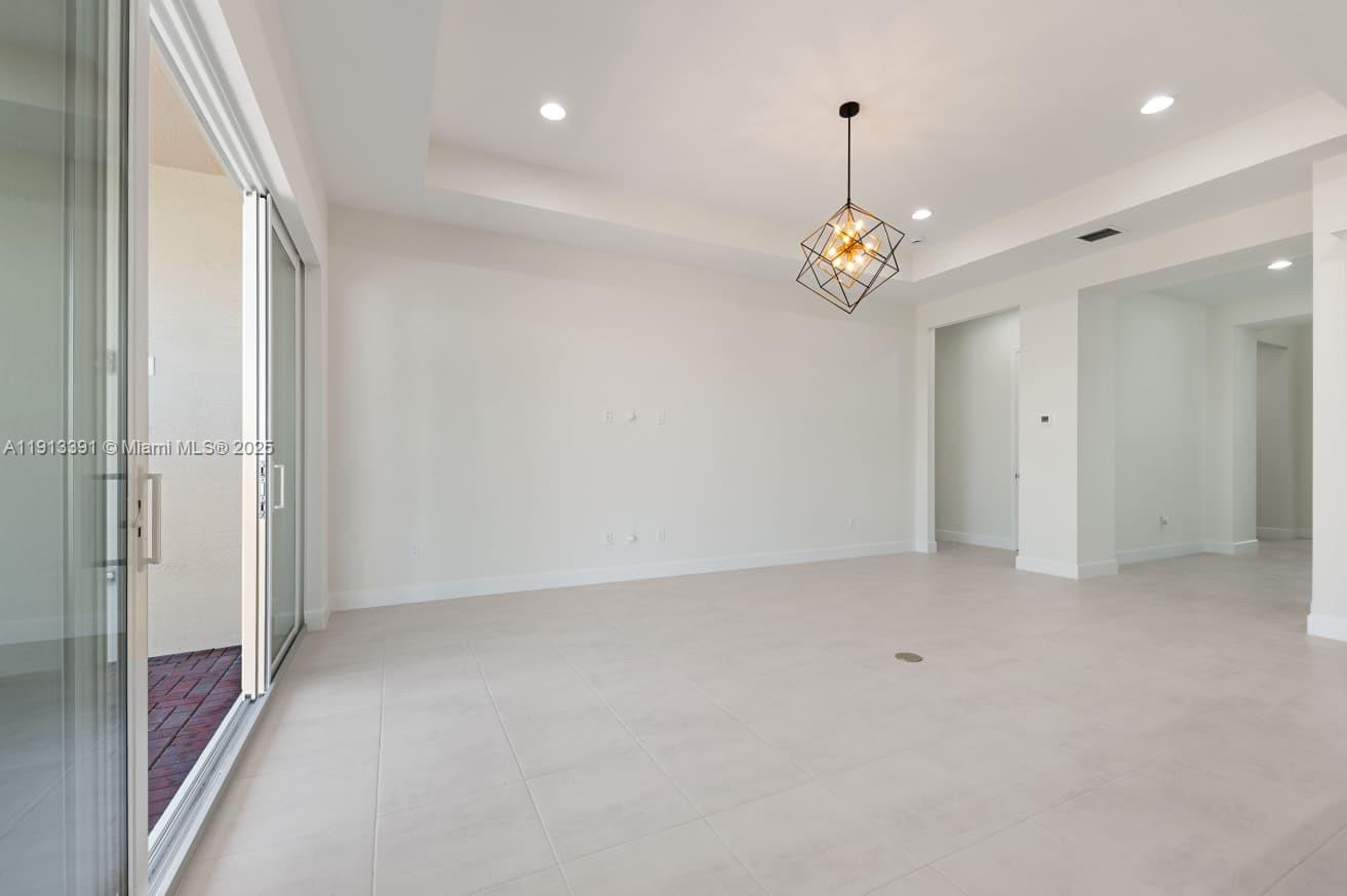 5786 Aleppo Pne Place Westlake, FL 33470 - Photo 10 of 30 an empty room with chandelier fan and windows