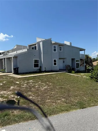 a view of a house with backyard and trees