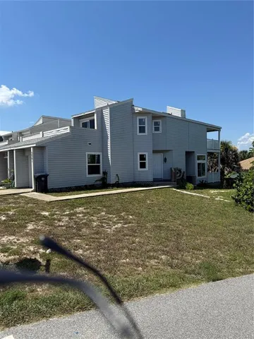 a view of a house with backyard and trees